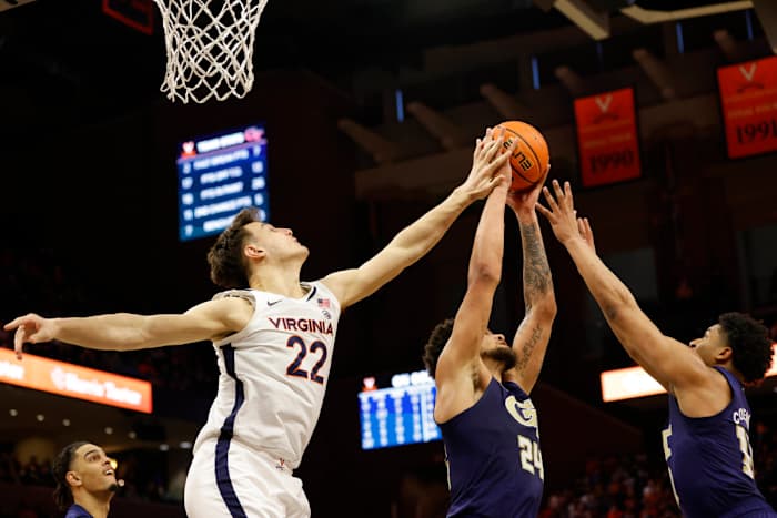 Virginia Cavaliers center Francisco Caffaro battles for a rebound with Georgia Tech Yellow Jackets center Rodney Howard and guard Dallan Coleman.